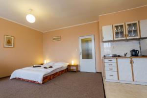 a bedroom with a bed and a kitchen with two candles at Hotel Koruna in Roudnice nad Labem