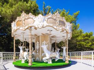 a white carousel with animals on it in a park at Yaward Resort - Taoyuan Golf & Country Club in Longtan