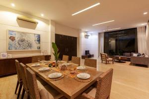 a dining room with a wooden table and chairs at StayVista at Bella Orion with Pvt Pool- North Goa in Calangute