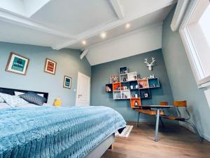 a bedroom with a blue wall with a bed and a desk at Villa Metz / Amnéville 200m2 in Vigy