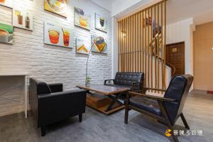 a living room with a table and chairs and a staircase at Harbour Enjoy Homestay in Yilan City