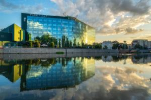 a building with its reflection in a body of water at HP Park Plaza in Wrocław