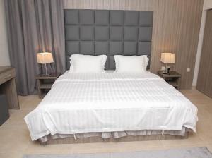 a bedroom with a large white bed with two lamps at شقق الراحه للشقق المخدومة in Jeddah +21 photos