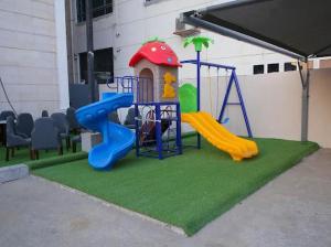 un parque infantil con tobogán y estructura de juegos en Al Raha Apartment Hotel en Yeda