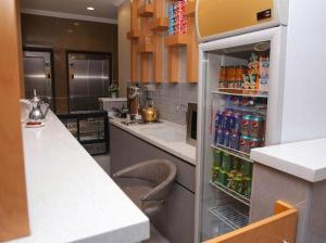 a kitchen with a refrigerator filled with drinks at Al Raha Apartment Hotel in Jeddah