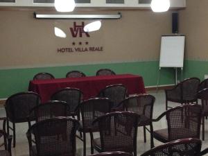a room with a table and chairs and a white board at Hotel Villa Reale in Argenta
