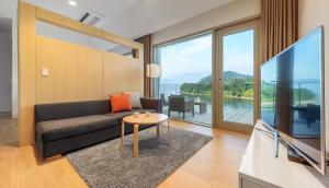 a living room with a couch and a tv at Bayclub in Namhae