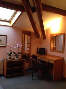 a room with a desk with a computer and a mirror at Hotel Villa Reale in Argenta