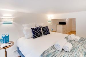 una camera da letto con un grande letto bianco con asciugamani di Sweet Inn - Rue de Lallier a Parigi
