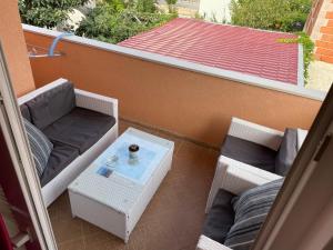 a balcony with a table and a couch and a coffee table at Apartments Dumina in Murter