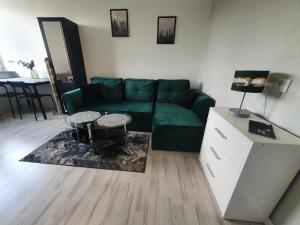 uma sala de estar com um sofá verde e uma mesa em Forest House em Dębica