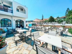 ヘルソニソスにあるDimitra Hotelのテーブルと椅子付きのレストランのパティオ