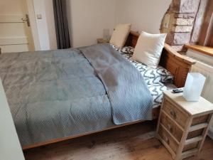 a bedroom with a bed and a table with a night stand at Ferienwohnung Im VitalArt Naturgarten in Zweibrücken