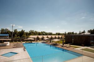 a pool at a resort with chairs and umbrellas at Castel Mimi Boutique Hotel in Bulboaca