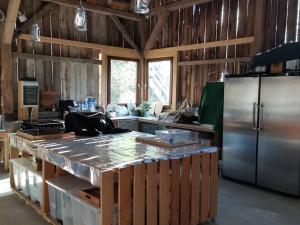 a kitchen with a stainless steel refrigerator and a counter at Ferienwohnung Im VitalArt Naturgarten in Zweibrücken