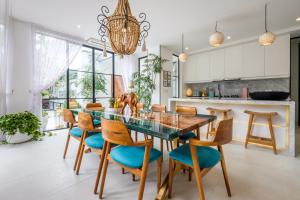 una cucina e una sala da pranzo con tavolo e sedie in vetro di Maison Jolie Villa by Hombali a Canggu