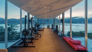 a gym with a view of the water and mountains at Bayclub in Namhae