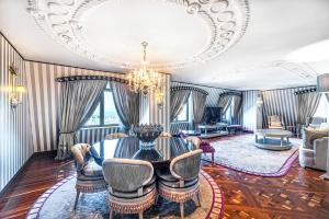 a living room with a table and chairs and a chandelier at Wyndham Grand Istanbul Kalamış Marina Hotel in Istanbul