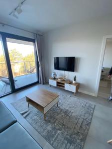 a living room with a coffee table and a large window at Apartament Natural 306 z widokiem na morze in Darłówko