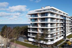 an apartment building with the ocean in the background at Apartament Natural 306 z widokiem na morze in Darłówko