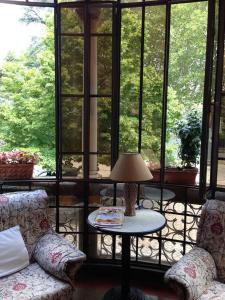 a room with two chairs and a table with a lamp at Hotel Villa Reale in Argenta