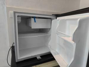 einem leeren Kühlschrank mit offener Tür in der Küche in der Unterkunft Mysore Studio Rooms in Mysore