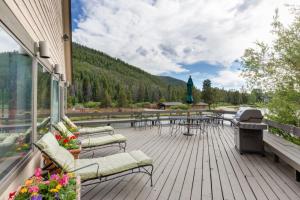 a deck with tables and chairs and a grill at Lakeshore by Summit County Mountain Retreats in Keystone