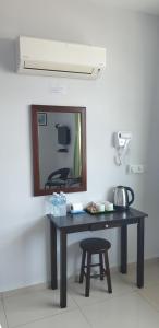 a table in a room with a mirror and a stool at 56 HOTEL in Mentekab