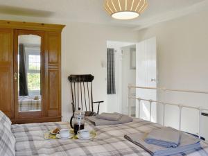 een slaapkamer met een bed met een dienblad met eten erop bij Apple Tree Cottage in Bassenthwaite