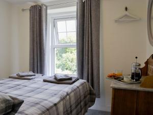 een slaapkamer met een bed en een raam bij Apple Tree Cottage in Bassenthwaite