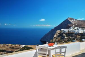 a white table and chairs sitting on top of a hill at Belvedere Apartments in Chora Folegandros
