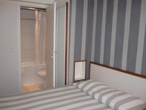 a bedroom with a bed with a striped wall at Hotel Royal Bergère in Paris