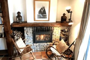 a living room with a fireplace and two chairs at Holiday home Keysersnest in Gistel