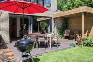 un patio con barbecue e tavolo con griglia di Holiday home Keysersnest a Gistel