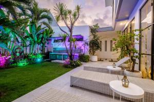 un jardin intérieur avec des palmiers et des lumières dans l'établissement Maison Jolie Villa by Hombali, à Canggu