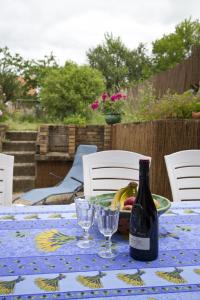 einen Tisch mit einer Flasche Wein und Gläsern darauf in der Unterkunft Le Bourdon bleu à Celles en Bassigny in Celles-en-Bassigny