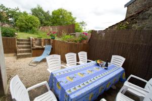 a table with white chairs and a blue table cloth at Le Bourdon bleu à Celles en Bassigny in Celles-en-Bassigny