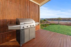 a grill on a wooden deck with a backyard at 136 Madaffari Drive in Exmouth