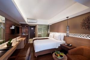 ein Schlafzimmer mit großem Bett und ein Wohnzimmer in der Unterkunft Ramada by Wyndham Bali Sunset Road Kuta in Kuta