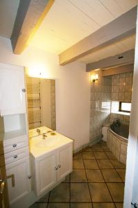 a bathroom with a white sink and a tub at Le Bourdon bleu à Celles en Bassigny in Celles-en-Bassigny