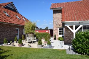 a garden with trees and a bench in front of a building at Wellness Appartements in Ihlowerfehn