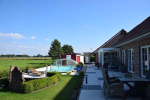 a backyard with a pool and a house at Wellness Appartements in Ihlowerfehn