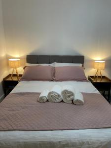 1 cama con 2 toallas y 2 lámparas en Lovely 2 Bedroom Serviced Apartment with Parking, en West Bromwich