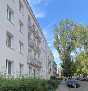 華沙的住宿－Górska Apartament，一座白色的公寓楼,旁边设有停车场
