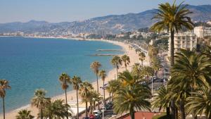 vistas a una playa con palmeras y al océano en Villa Cannes directly on the sea en Cannes