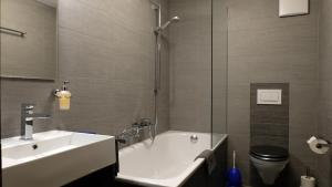 采爾馬特的住宿－伽尼藝術公寓和酒店，带浴缸、盥洗盆和卫生间的浴室