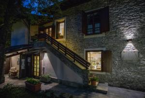 a stone house with a staircase and windows at night at Fermata Alpi Graie 