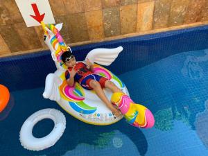 a young man riding on a unicorn raft in a swimming pool at White Swan Private VIlla in Tlekung