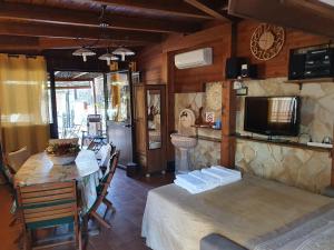 a dining room with a table and a television at La Dependance delle Mimose in Isola delle Femmine