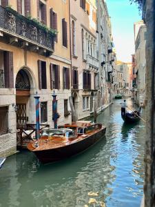 a couple of boats in a canal between buildings at Hotel Becher in Venice